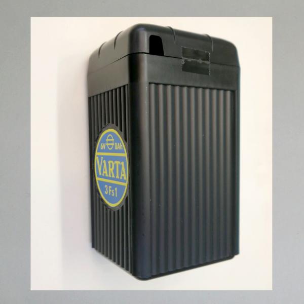 Batteriegehäuse leer, schwarzes Kunststoffgehäuse mit Deckel und Beschriftung "Varta"